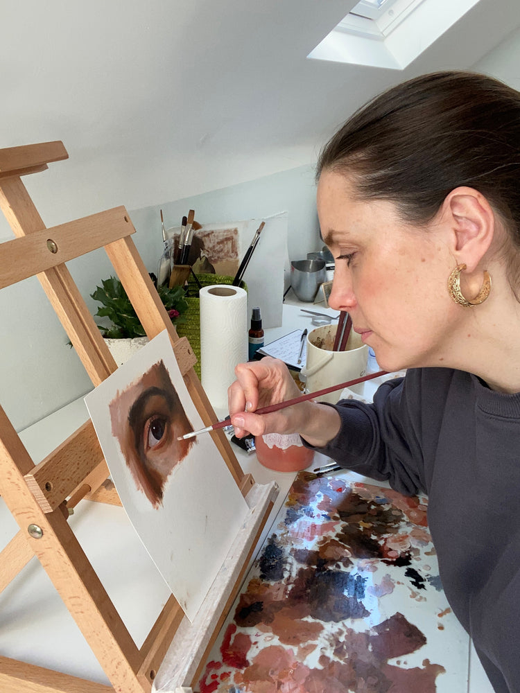 Louise painting an eye painting in her studio